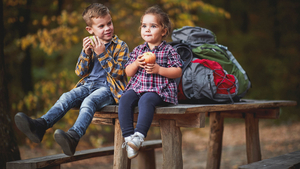 Kinder essen bei einem Ausflug in der Natur einen Apfel Kinder essen bei einem Ausflug in der Natur einen Apfel
