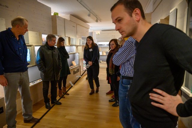 Personen betrachten ein Seil, an dem die verschiedenen Zeitepochen markiert sind.