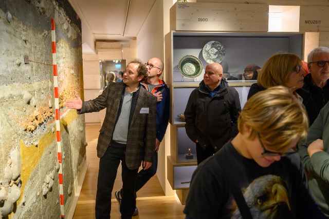 Besucher vor einem Grabungsprofil