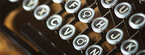 Antike Schreibmaschine, wobei zwei der Tasten durch die Symbole für "männlich" und "weiblich" ersetzt wurden.