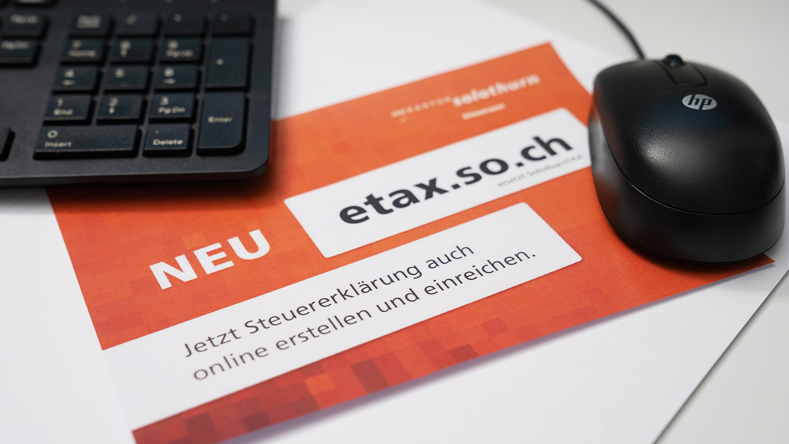 eTax-Broschüre neben Tastatur und Maus