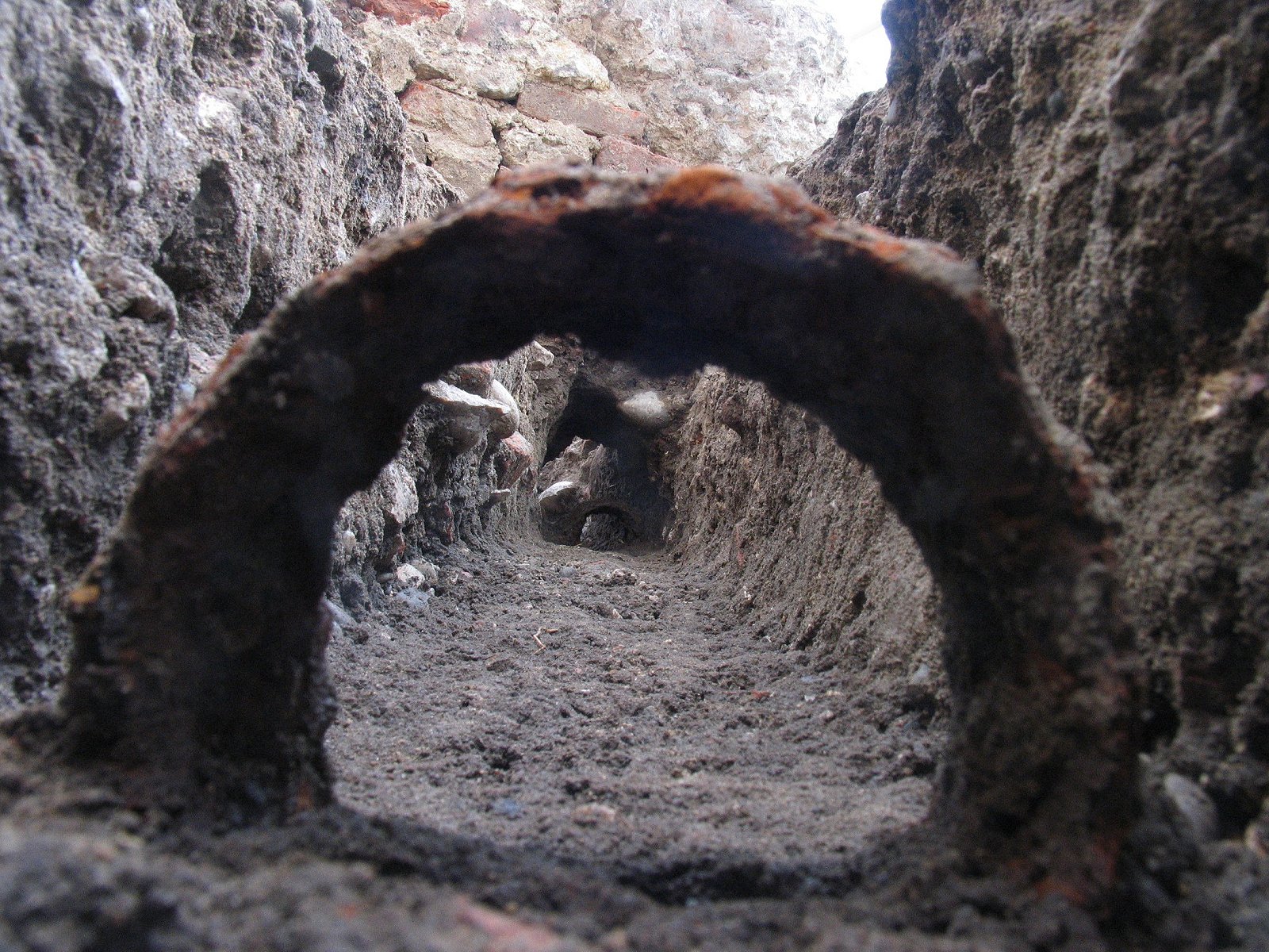 Blick durch eine Eisenmuffe einer vergangenen hölzernen Wasserleitung
