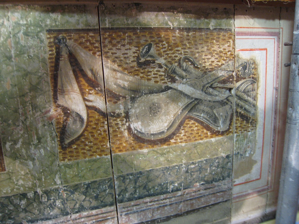 Spätbarocke Dekorationsmalereien des unteren Ranges zeigen Embleme aus der Welt des Theaters